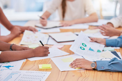 Midsection of business colleagues working on table