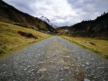 Road leading towards mountain against sky