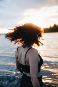 Rear view of woman standing at beach