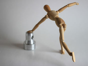 Close-up of figurine on table against white background