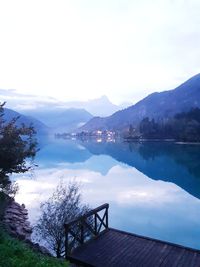 Scenic view of pier by lake and mountains against sky