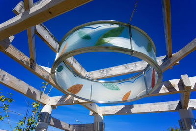 Low angle view of metallic structure against blue sky