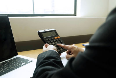 Midsection of man using mobile phone