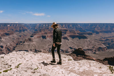 Full length of man standing on rock against sky