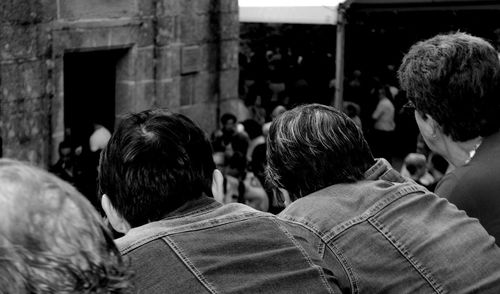 Rear view of people against built structure