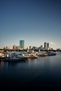 View of city skyline with river and marina in front against blue sky