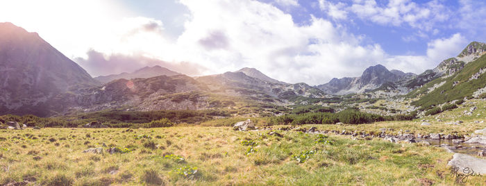 Scenic view of field and mountains against sky