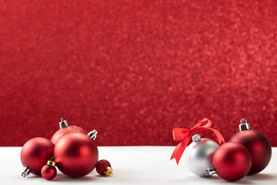 Close-up of baubles on table against red background