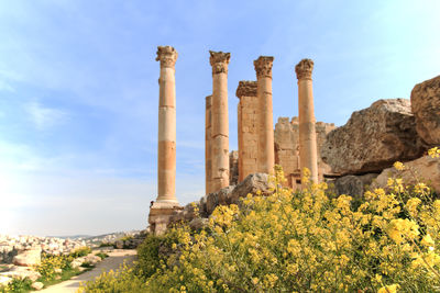 Low angle view of columns at old ruin against sky