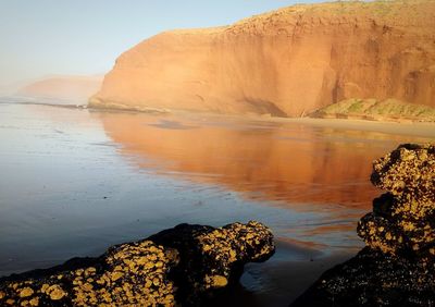 Rock formations by sea against sky