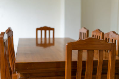 Close-up of chairs on table at home