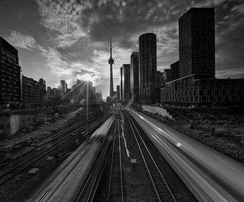 Railroad tracks amidst buildings in city against sky