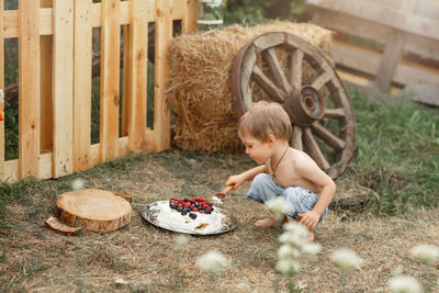 Side view of cute baby sitting on land