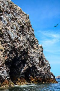 Rock formation by sea against sky