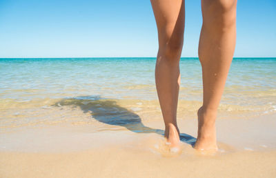 Low section of woman standing on beach