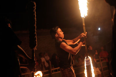 Woman holding lit candles at night