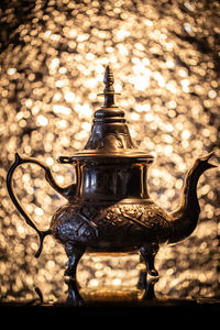 Close-up of vintage teapot on table against window