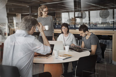 Multi-ethnic business people working at table in office cafe