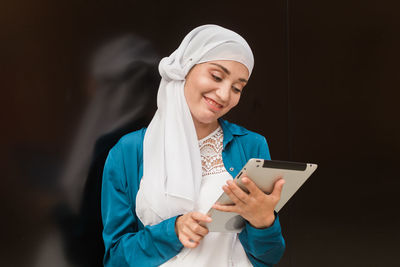 Smiling woman using digital tablet outdoors