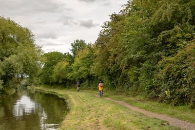 Cycling on the towpath of the trent and mersey canal at stenson near derby with trees and bushes.