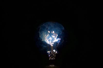 Close-up of illuminated light bulb in darkroom