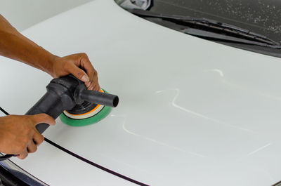 Midsection of man cleaning car at garage