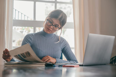 Businesswoman using laptop while sitting on table