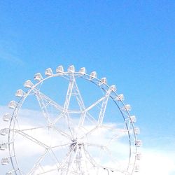 Low angle view of ferris wheel against clear blue sky