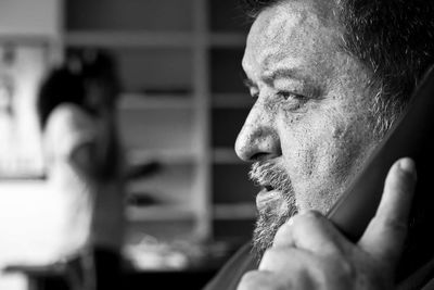 Close-up of mature man talking on landline phone at home