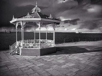 Pier on sea against cloudy sky