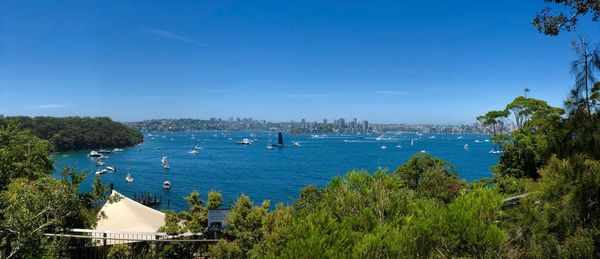 High angle view of bay and buildings against blue sky