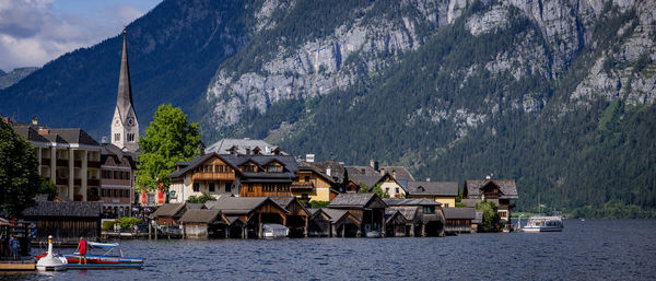 Houses by sea against sky