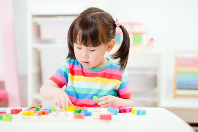 Cute girl playing with toy at home