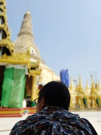 Rear view of man against temple against building