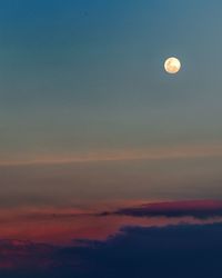 Low angle view of moon in sky at sunset