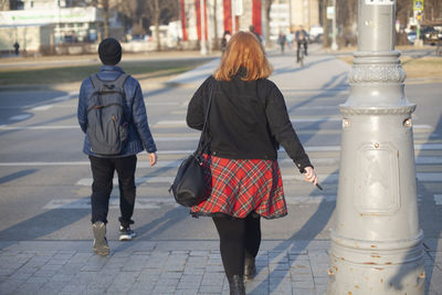 Rear view of people walking on footpath