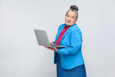 Mid adult man using smart phone against white background