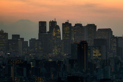 View of skyscrapers in city at sunset
