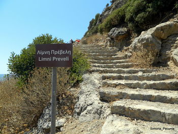 Information sign on rock against sky