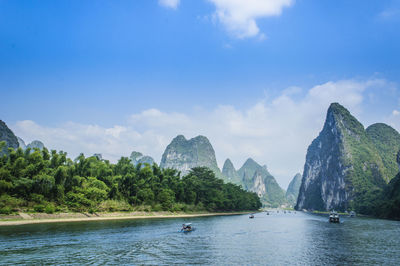 Scenic view of river and mountains against sky