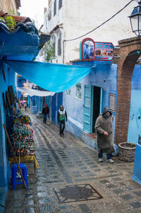 People walking on street against buildings in city