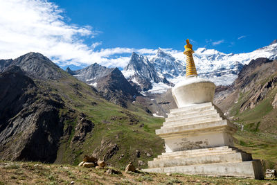 Panoramic view of temple against building and mountains against sky