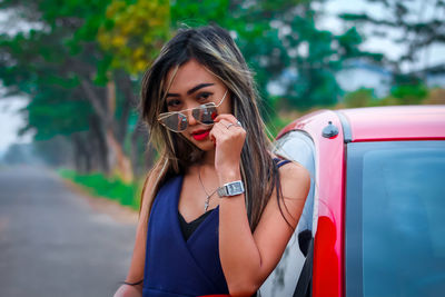 Portrait of young woman holding a car