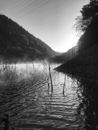 Scenic view of lake by silhouette mountain against sky