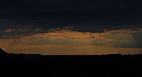 Silhouette of landscape against cloudy sky