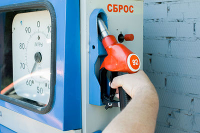 Cropped image of man holding fuel pump at gas station