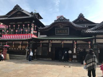 People at temple against sky