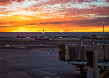 Airport runway against sky during sunset