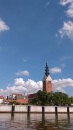 Church by canal against blue sky