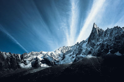 Low angle view of snowcapped mountains against sky